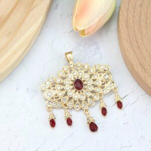 Broche dorée médiévale avec pierres rouges pendantes